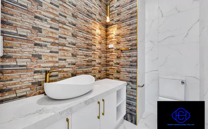 Powder Room Feature Wall — Stacked-stone feature wall with a floating vanity and marble finishes.