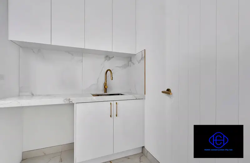 Marble Splashback & Cabinetry — Handle-less cabinetry with a marble splashback and brushed-gold tapware.